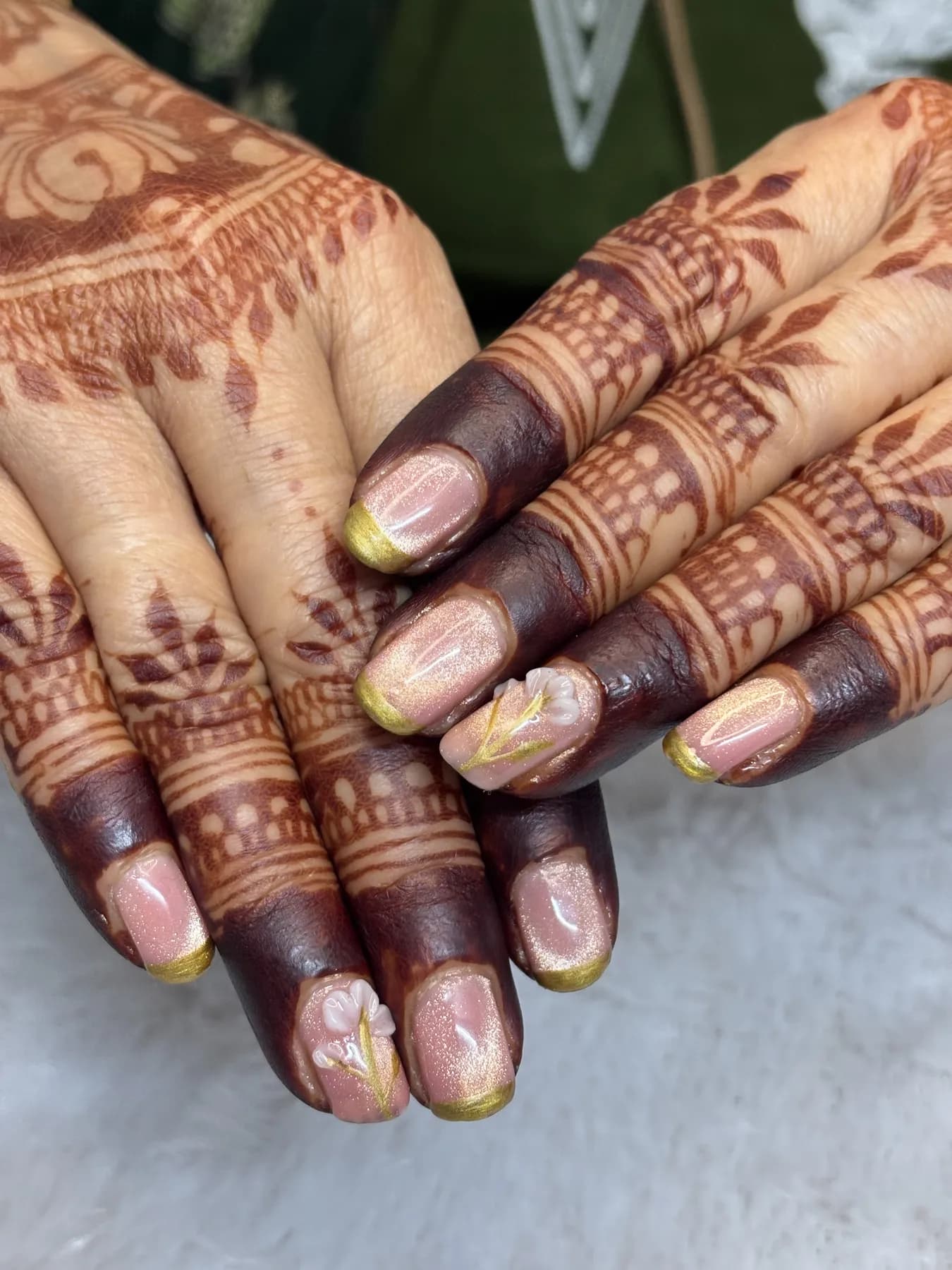 Rose gold French tip nails with 3D flowers and mhendi Ahmedabad