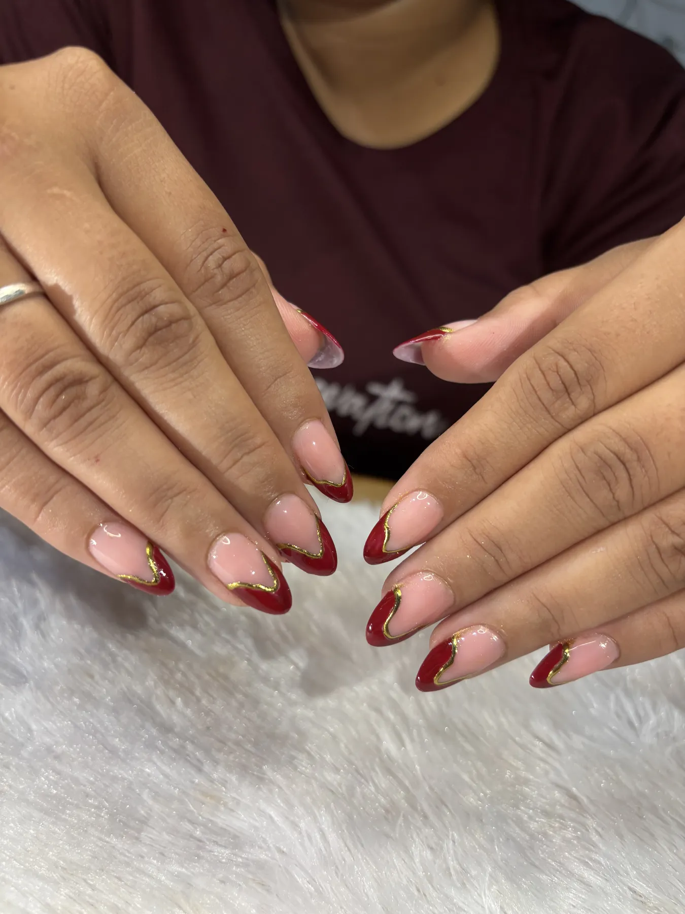 Burgundy and gold French tip nail art in Ahmedabad